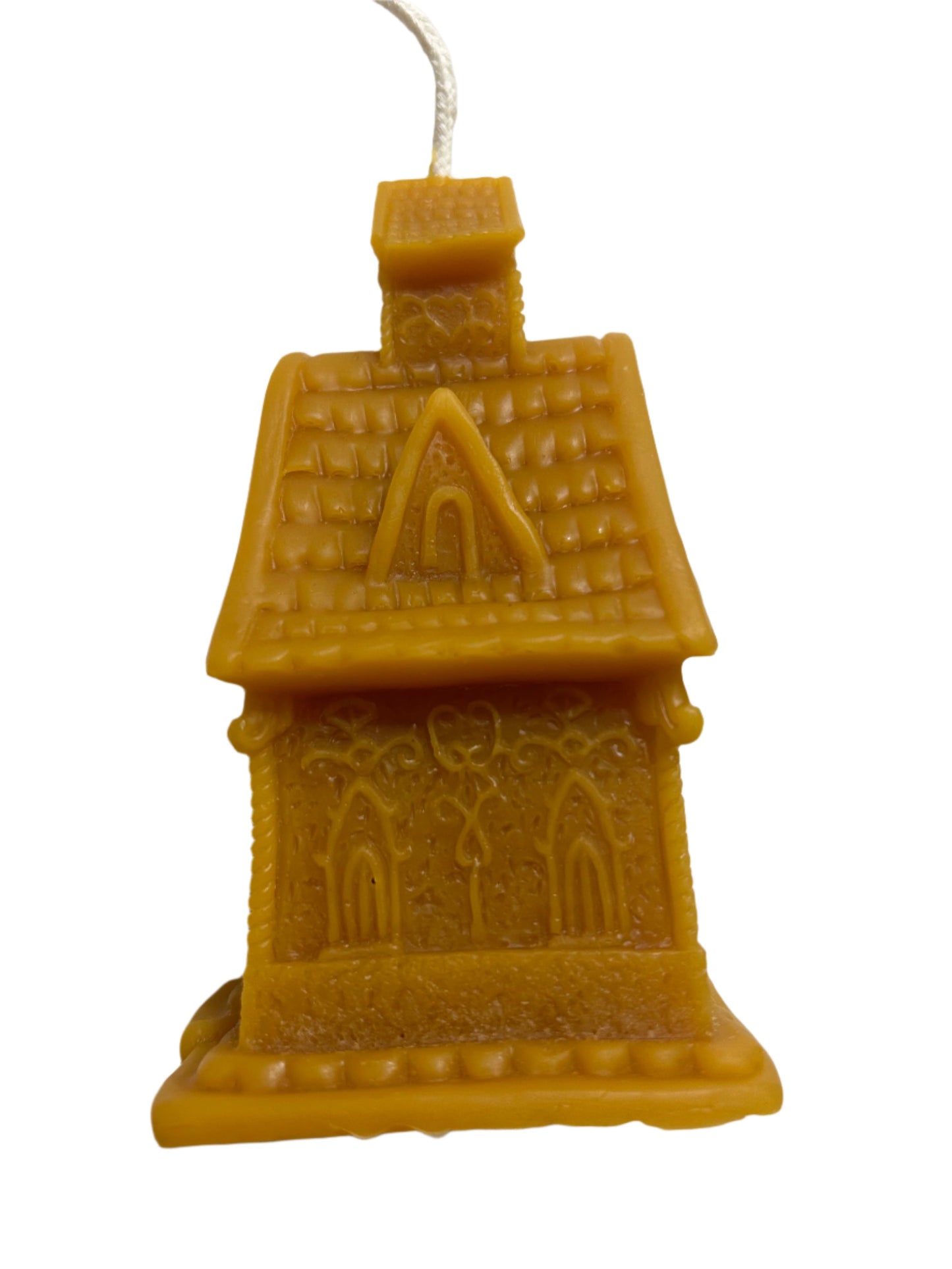 “Pure beeswax candle shaped like a detailed gingerbread house, featuring an arched door, ornate windows, and a textured roof, handcrafted for holiday decor or gifting.”